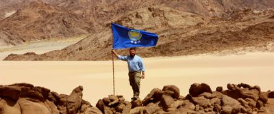Jeremiah Heaton holding his flag in the desert