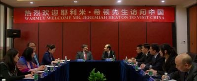 Jeremiah Heaton at a meeting under a banner welcoming him to China